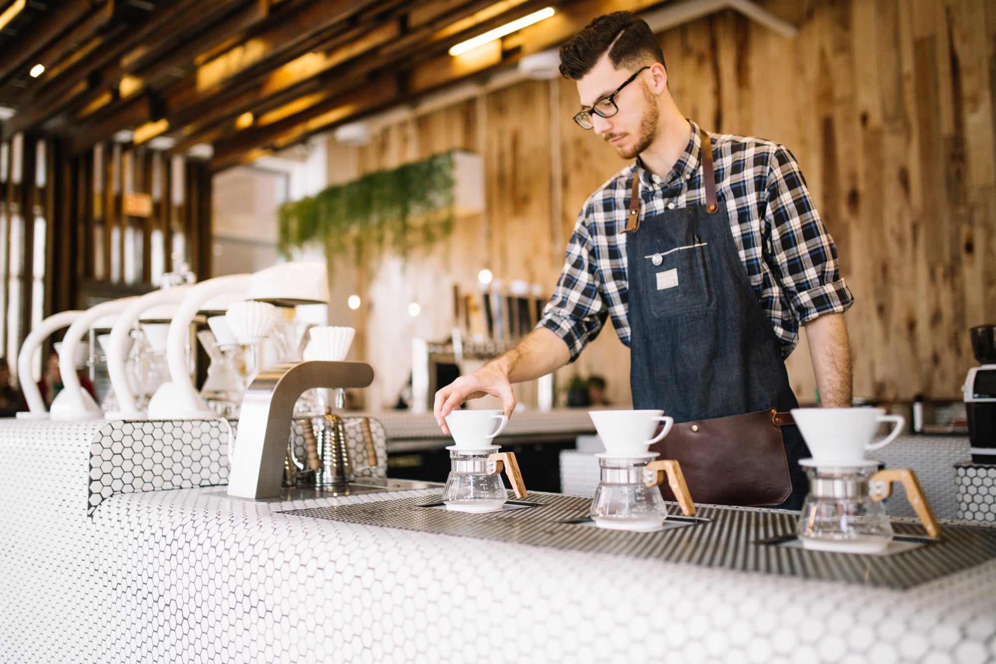 A barista preparing three coffees at once