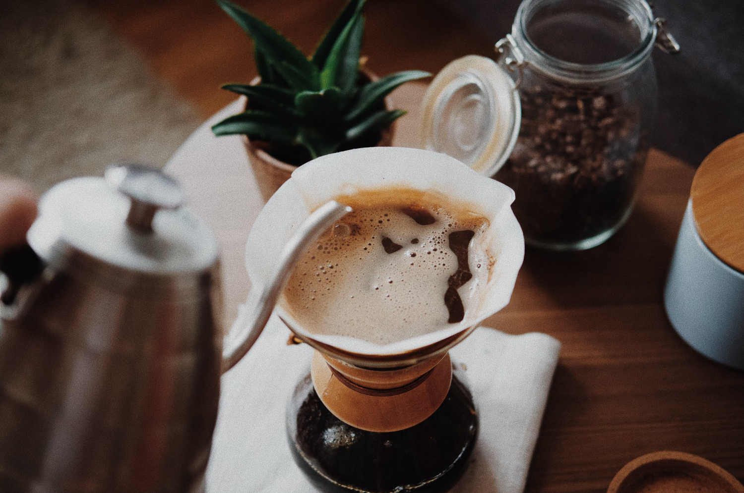 Top view of someone pouring hot water into a Chemex coffee maker